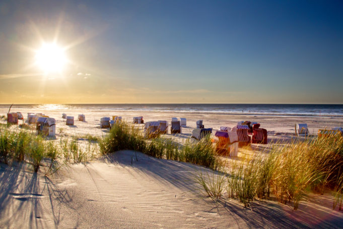 Beach with beach chairs in evening light on the beach of the north sea island Juist in East Frisia, Germany, Europe.