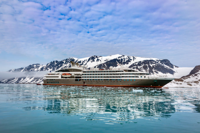 Cruise expedition ship bow passing icy snow arctic waters near Spitsbergen, Svalbard, Norway