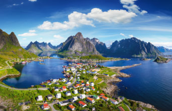 Reine, Lofoten, Norway. The village of Reine under a sunny, blue sky, with the typical rorbu houses. View from the top