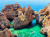 Ponta da Piedade - unique rock formation in the ocean - two boats with tourists visiting famous grottoes. Number one attraction in Lagos, Algrave, Portugal