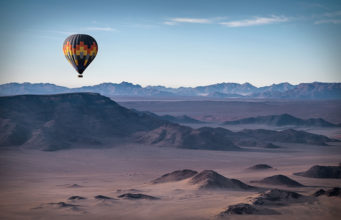 Colorful hot-air balloon flying over the high mountains in Namibia. High altitude. ( Namibia, South Africa)