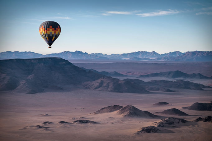 Colorful hot-air balloon flying over the high mountains in Namibia. High altitude. ( Namibia, South Africa)