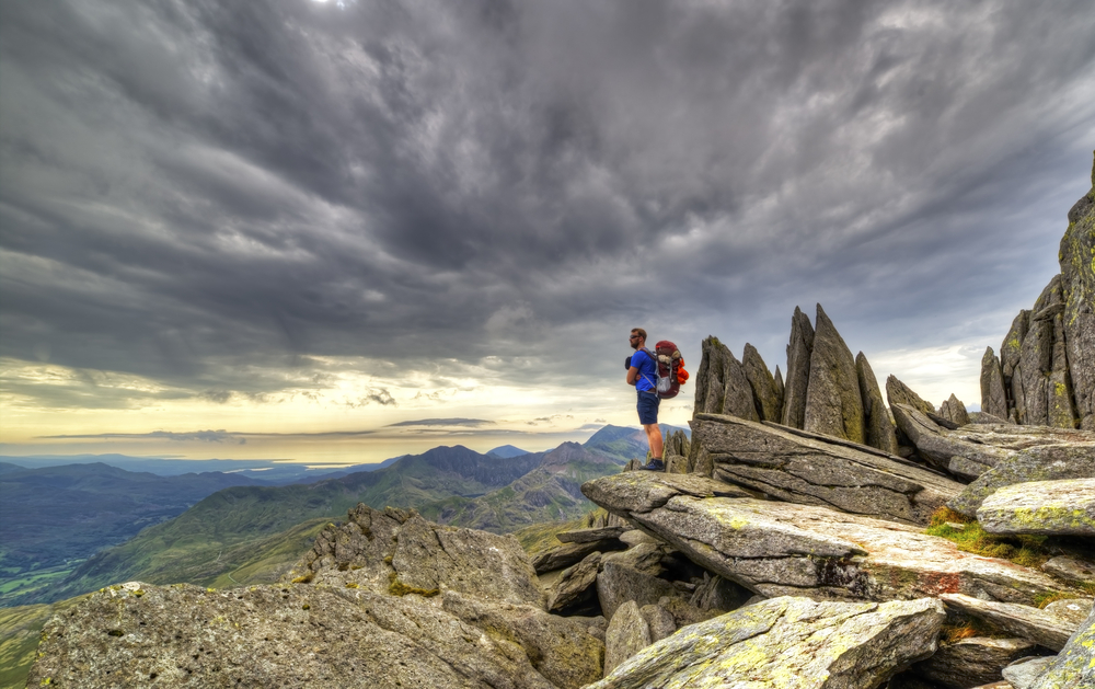 An explorer explores the Gylder Fach high up on Snowdonia moutain range in Wales. Emphasising exploration and traveling, backpacking and hiking in the outdoor world.