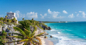 Lizenzfreie Stockfotonummer: 604913387 Ruins of Tulum, Mexico and a palm tree overlooking the Caribbean Sea in the Riviera Maya