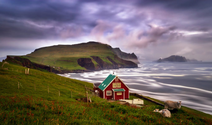 Lonely cabin with sheep on Mykinesholmur island in sunset, Faroe Islands