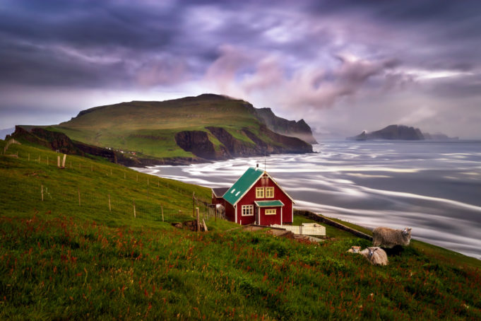 Lonely cabin with sheep on Mykinesholmur island in sunset, Faroe Islands